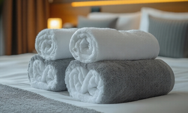 Premium white hotel towels stacked in luxury bathroom